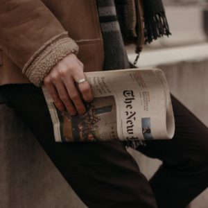 A person holds a newspaper